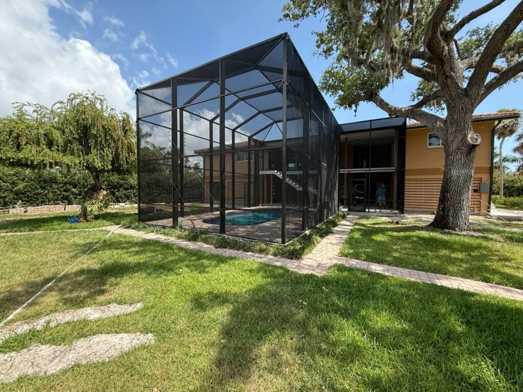 Completed screen room installation in Palm Coast, FL enclosing residential backyard pool